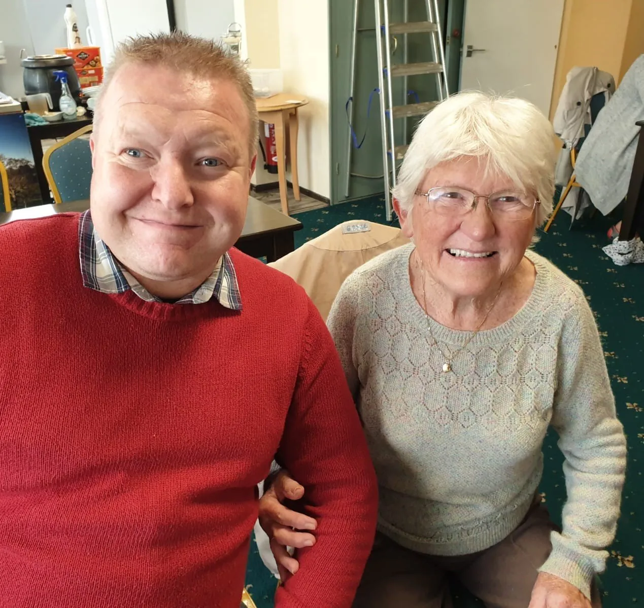 A support worker and an older lady smiling together
