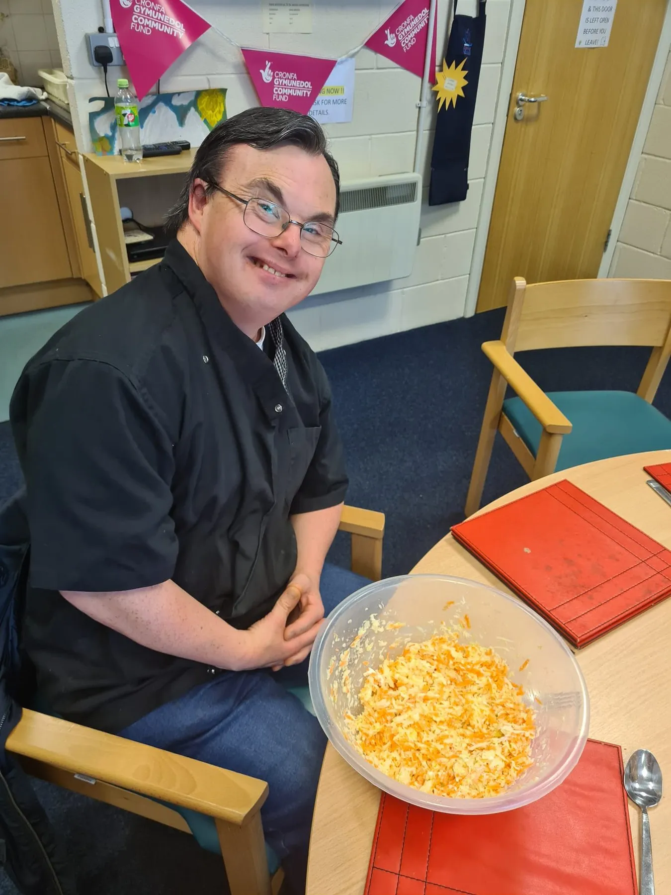 A man showing a bowl of food he has prepared