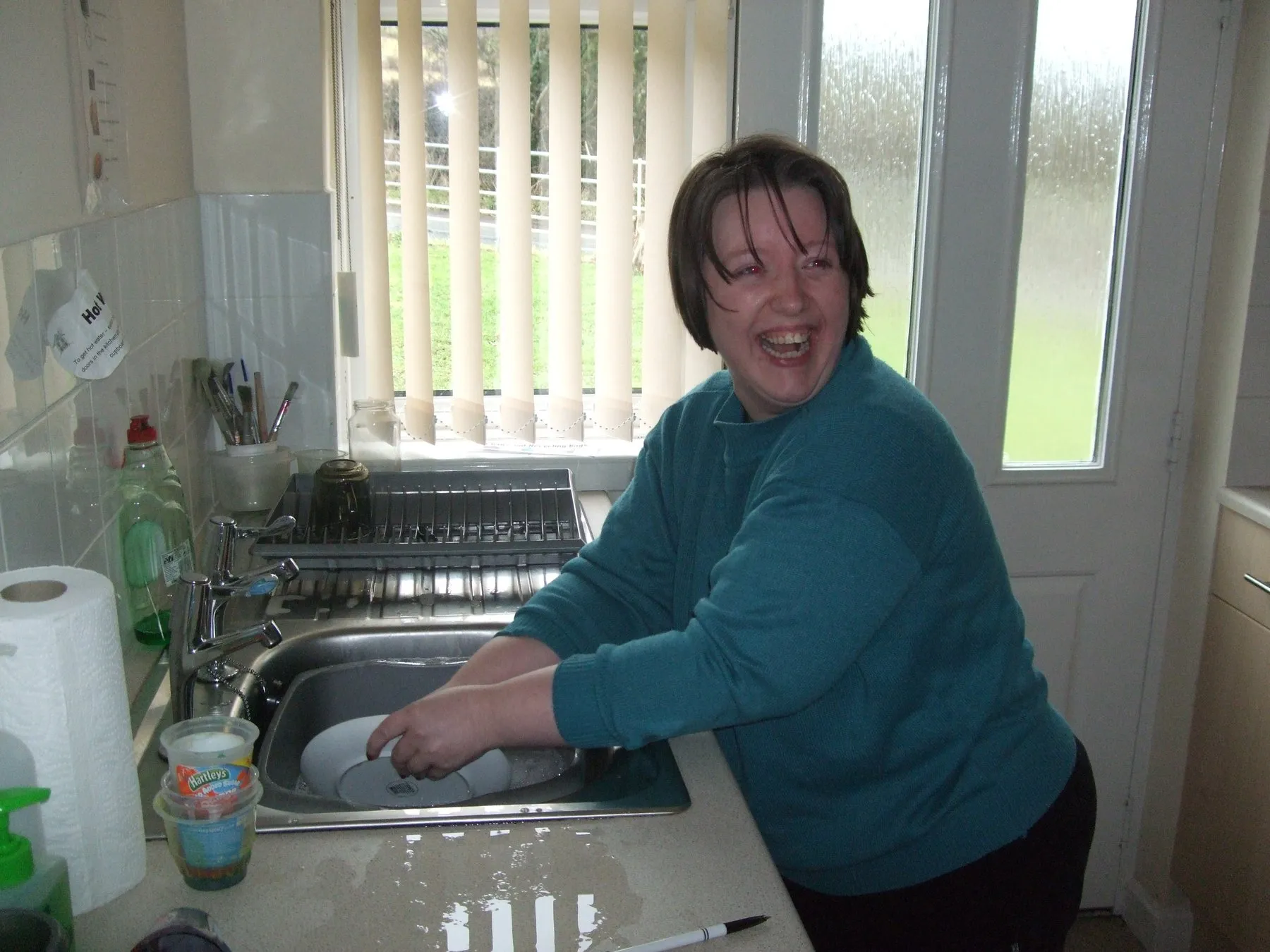 A lady washing up at a kitchen sink