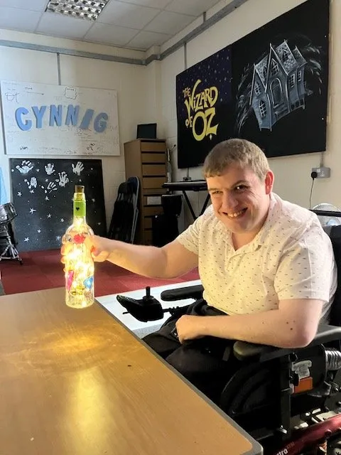 A member decorating a bottle in the Cynnig activity room