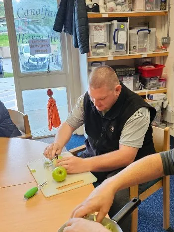 A member chopping an apple in the kitchen