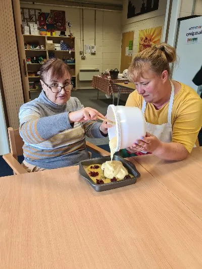 A member and a tutor cooking together in the kitchen