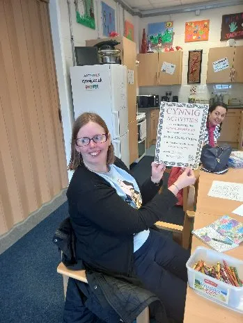 A lady showing a certificate she has received