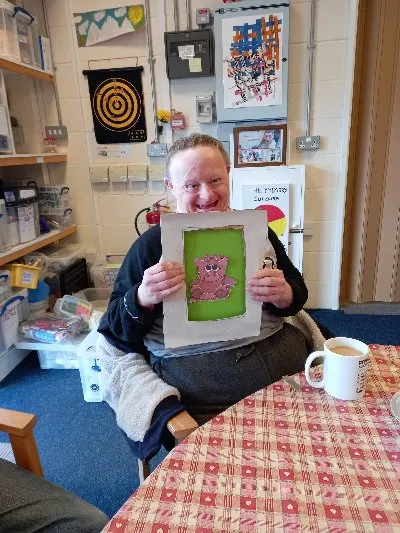A man holding up a picture he has made